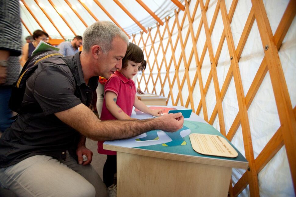 Un adulte accompagne un enfant dans la découverte des mondes