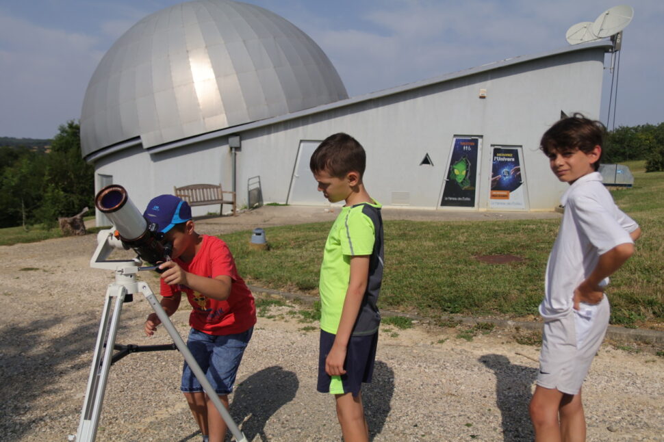 enfant observant le soleil au télescope