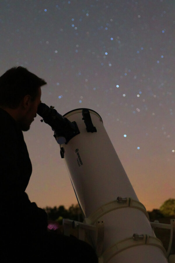 Homme observant le ciel au télescope Dobson